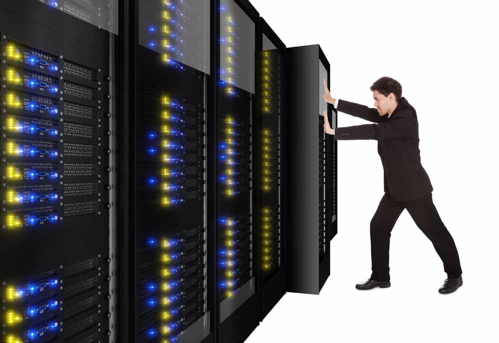 A data center migration is represented by a person physically pushing a rack of data center infrastructure into place