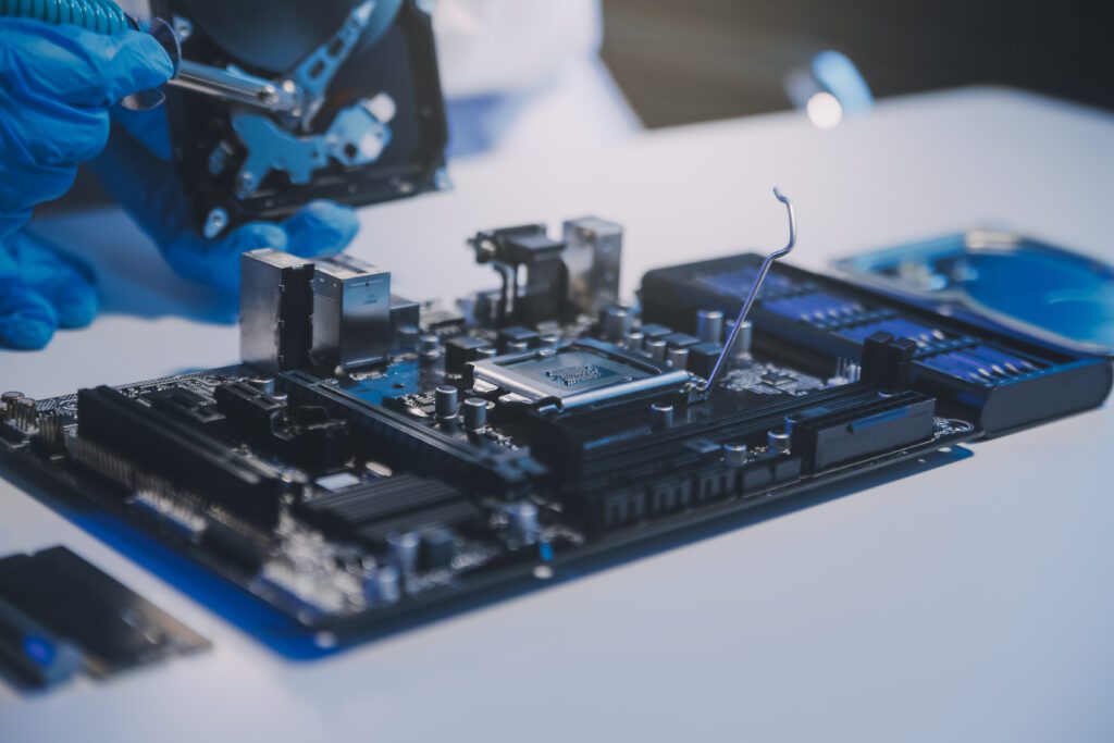 A technician assembles a motherboard to be used in hardware.